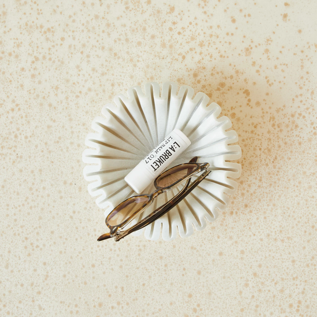 White marble pleated round bowl with a smooth interior.