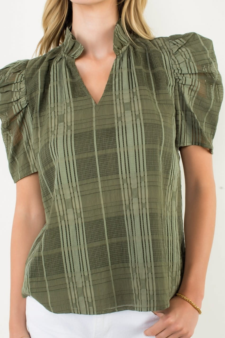 Front view of a gingham textured V-neck top with puff sleeves in light blue and white.