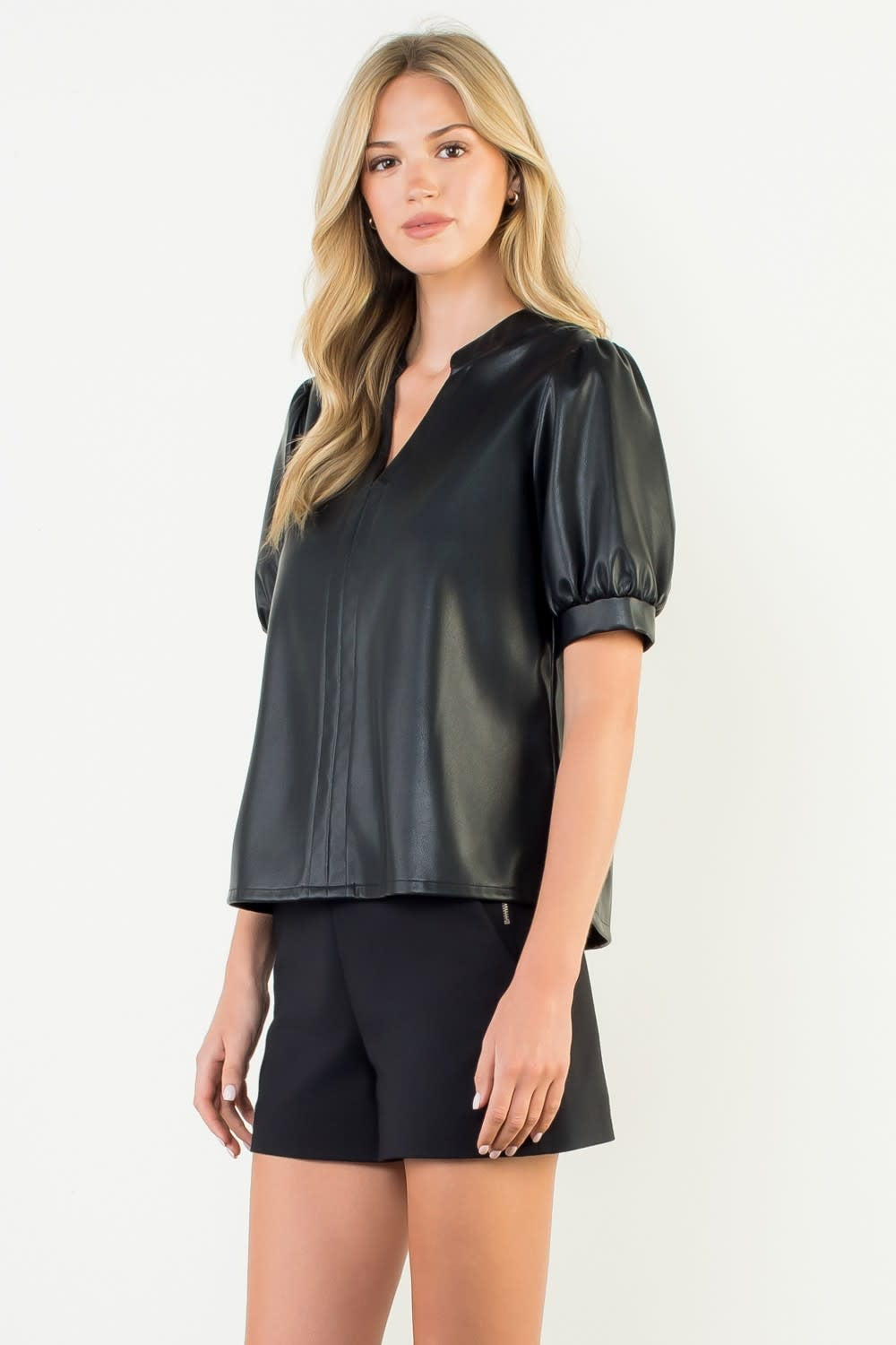 Black woven leather top with puff sleeves and a structured silhouette.