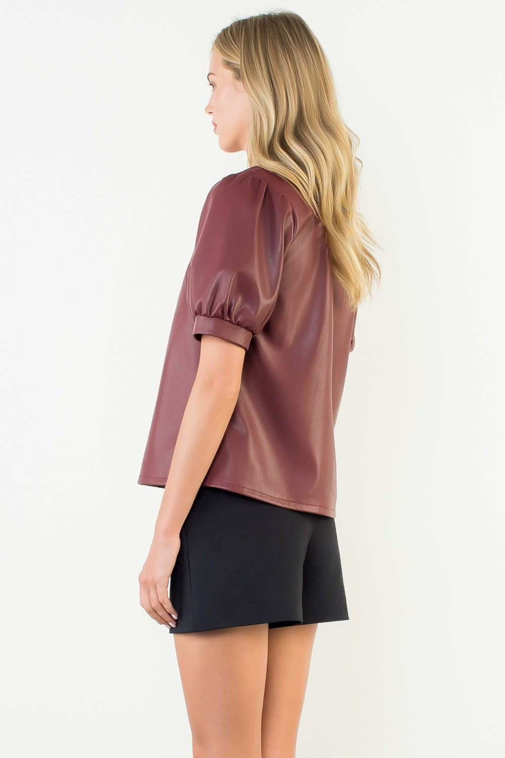 Back view of burgundy woven leather top with puff sleeves