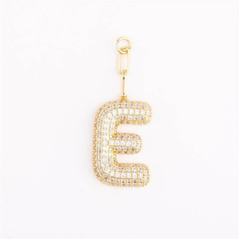 Heather-colored charm bag with gold plating, pave crystal setting, initial letter detail, and one-inch extender chain.