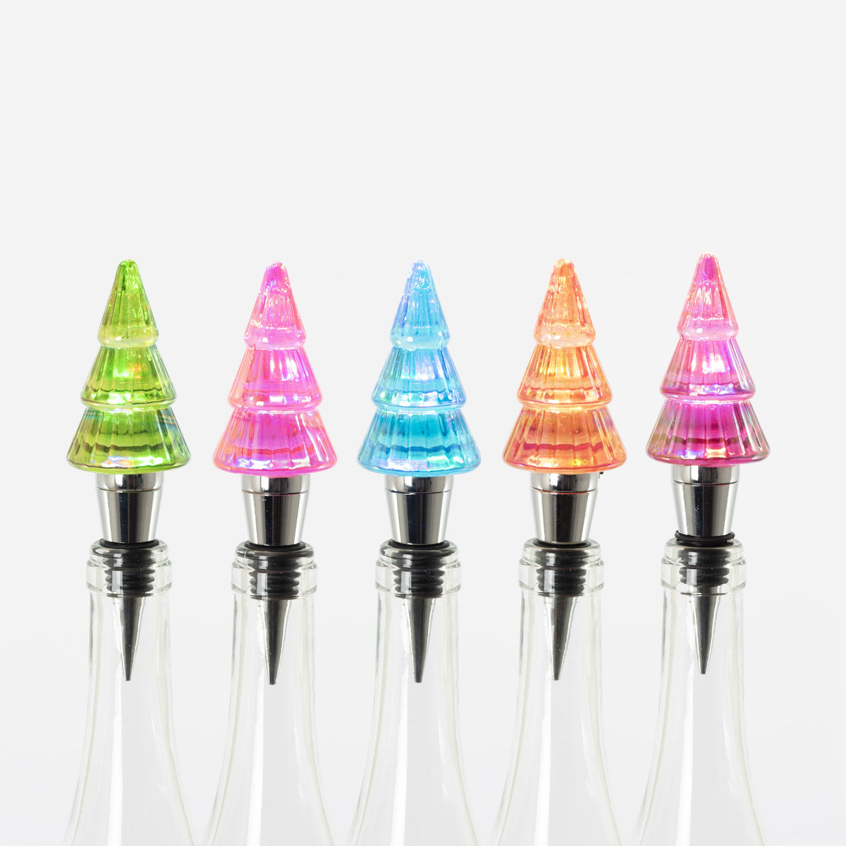 Five lit tree-shaped glass bottle stoppers in green, pink, blue, orange, and purple on glass bottles.