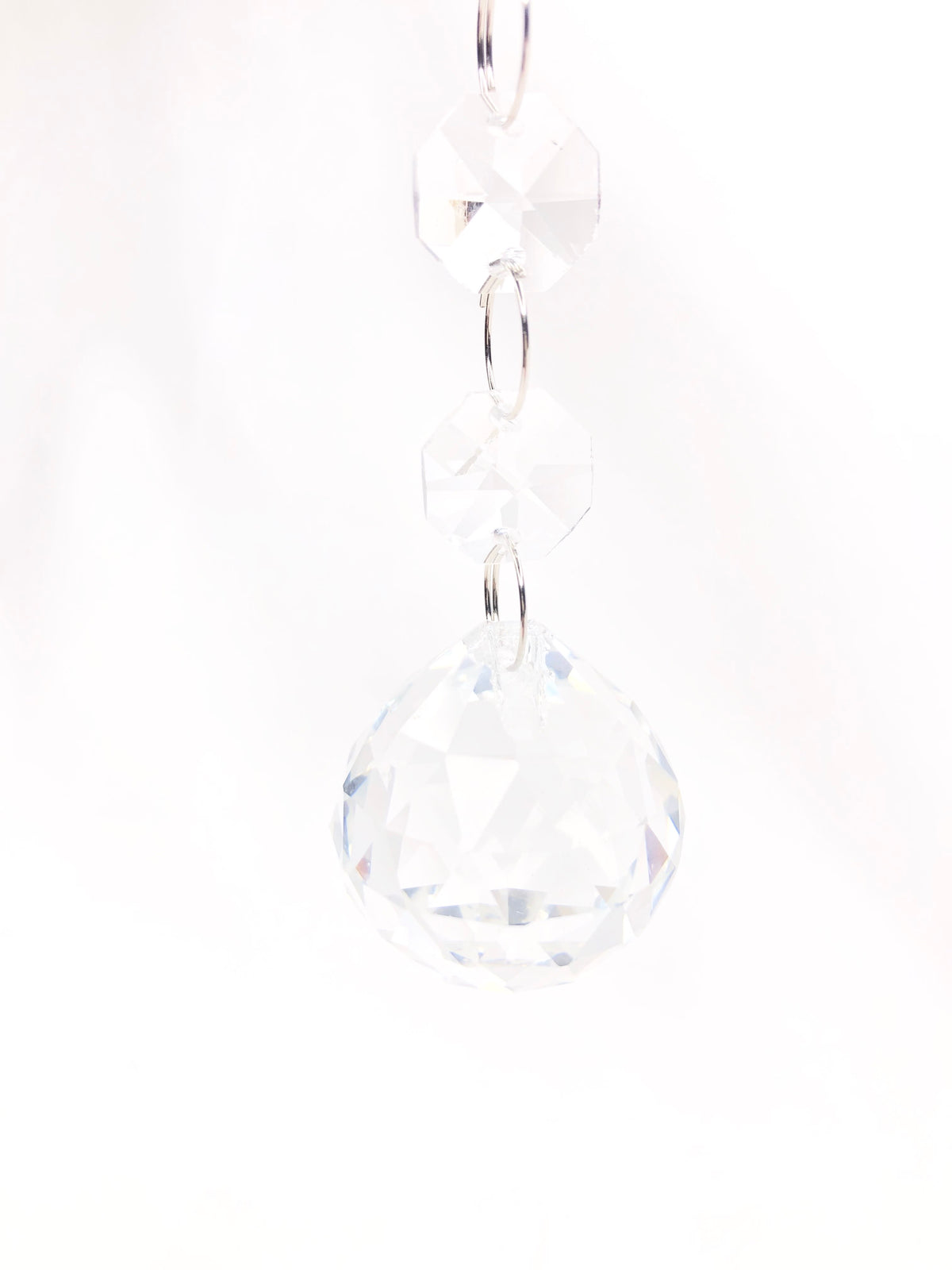 Crystal drop ornament featuring a large faceted glass ball suspended by two smaller octagonal beads.
