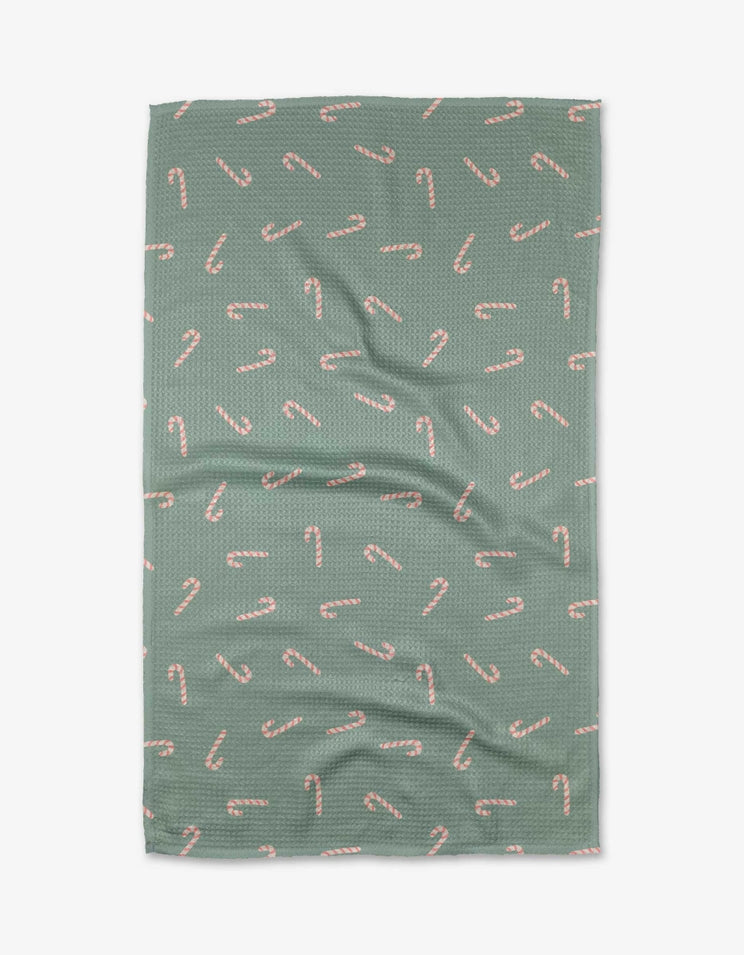 Holiday tea towel with waffle weave construction in red featuring a festive snowflake pattern and hanging loop.