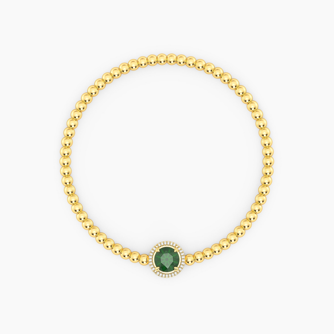 Gold-plated beaded bracelet with a round green center stone and a diamond halo.