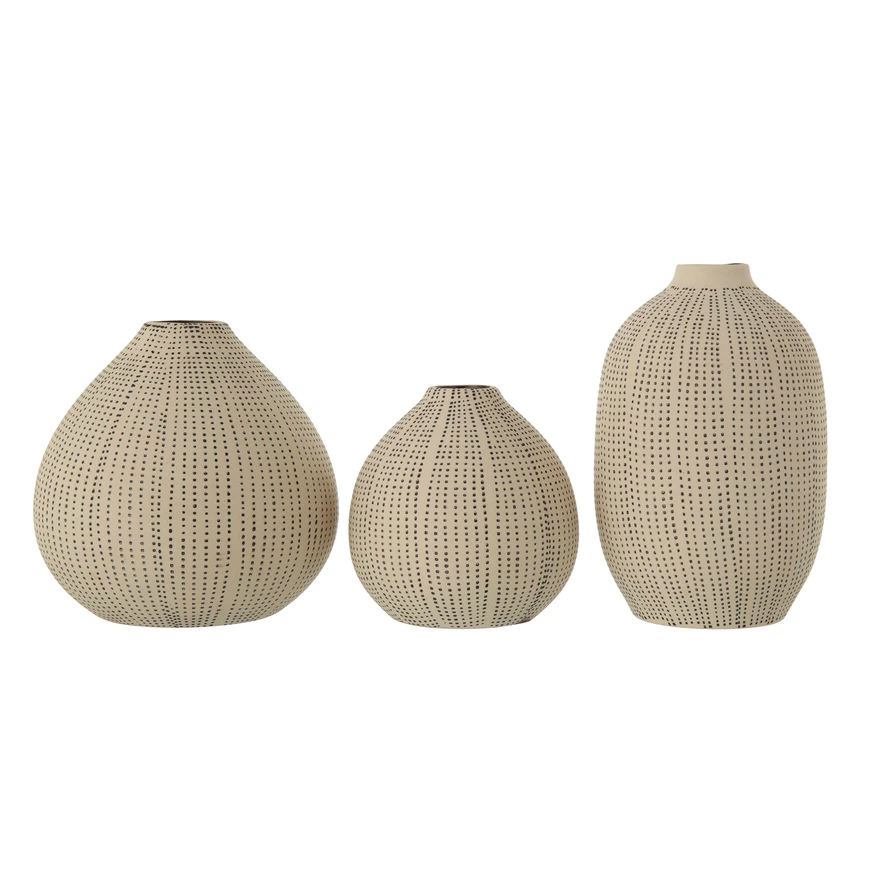 White stoneware vase with black polka dot texture on a round silhouette.