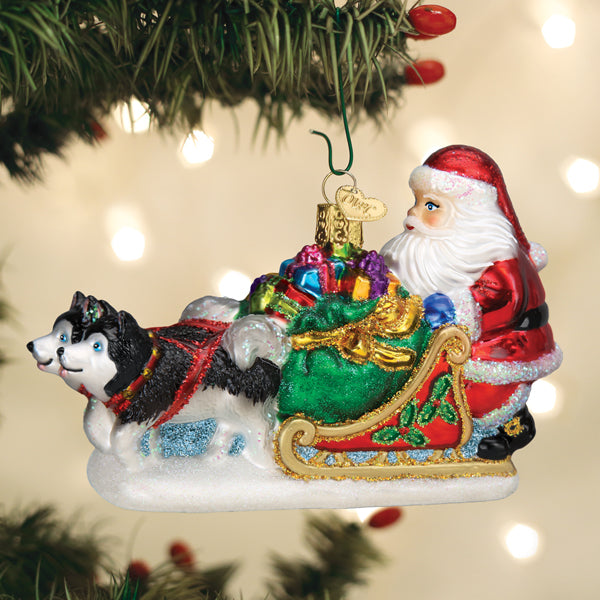 Glass Santa's Dog Sled ornament featuring Santa in a red suit on a sled pulled by two huskies.