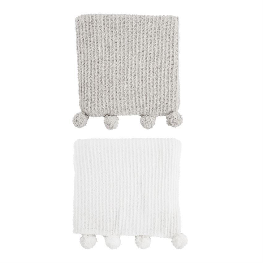Chenille pom blanket in soft beige with fluffy cream-colored ball fringe trim.