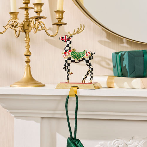 Westminster Deer Stocking Holder with a checkered pattern and gold antlers on a white mantel.