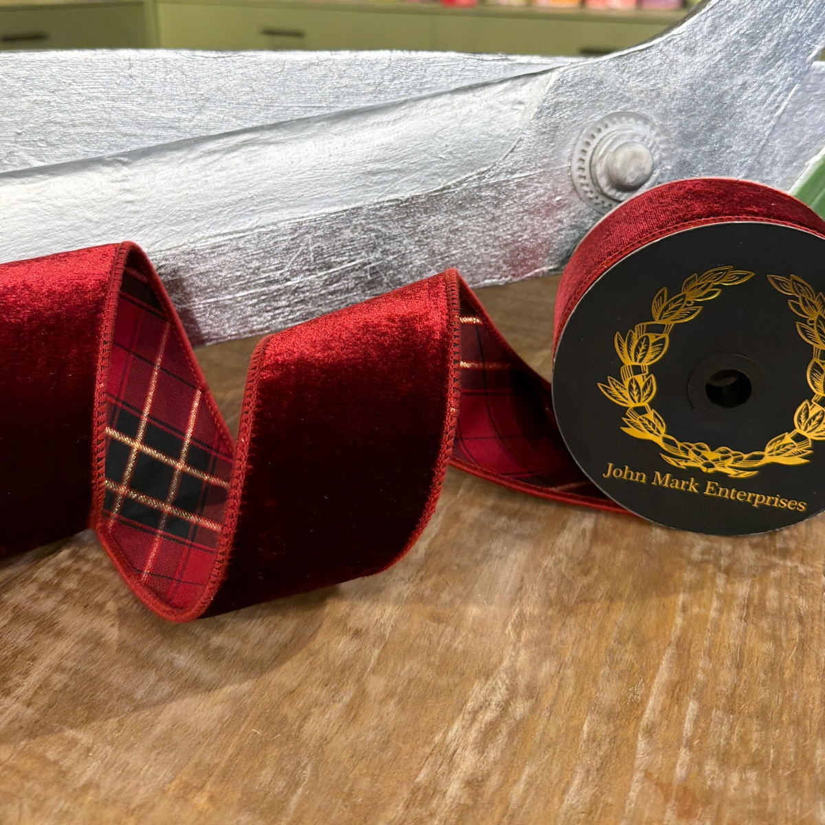 2.5 inch burgundy velvet ribbon with a red and black plaid trim on a spool.