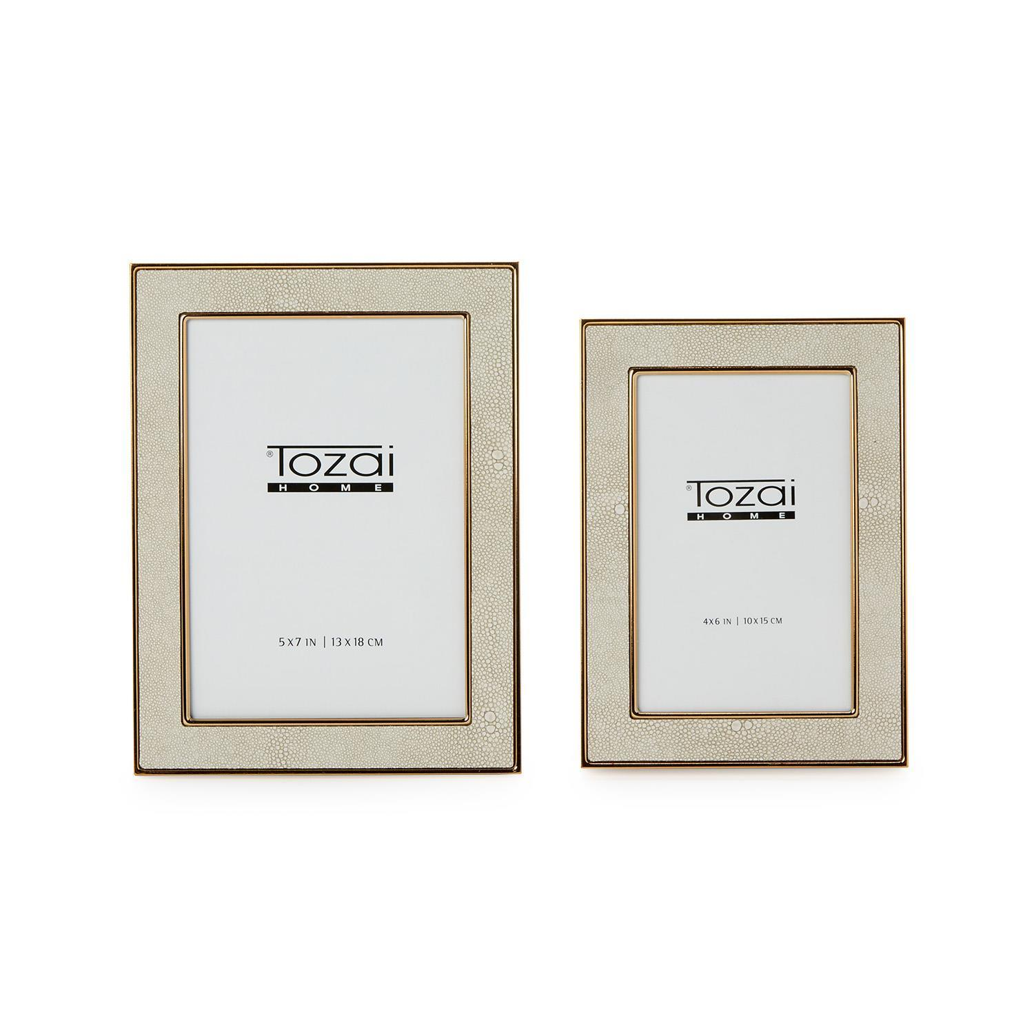 Two cream faux shagreen photo frames with gold steel trim in 5x7 and 4x6 sizes.