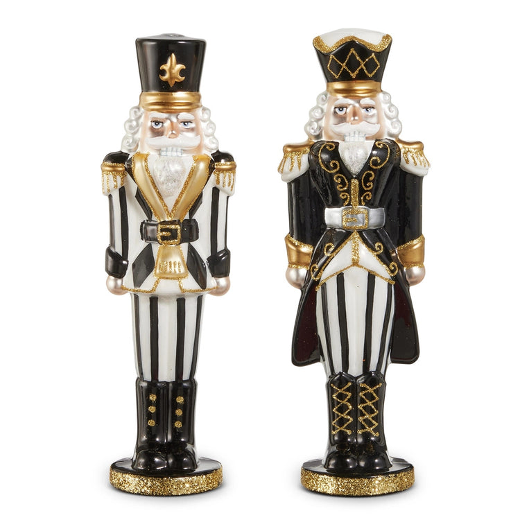 Two 10.5-inch glass nutcrackers in black and white with gold glitter accents and striped patterns.