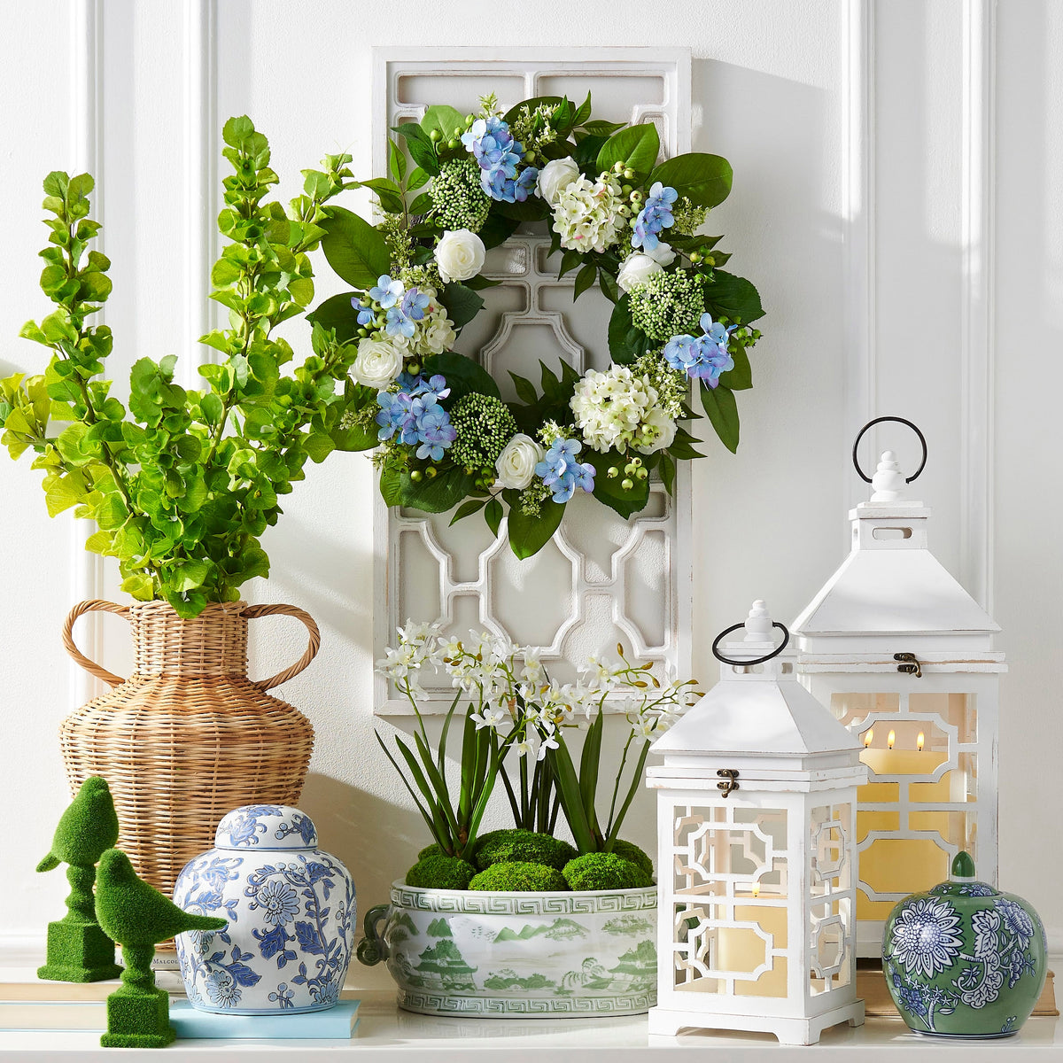 Clay jar with green and blue floral pattern on white background