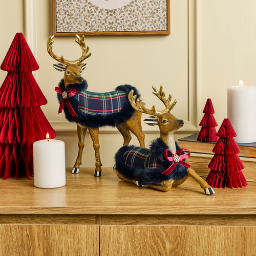 Timeless Tartan Resting Deer figurine with a navy plaid coat, red bow, and gold antlers on a shelf.