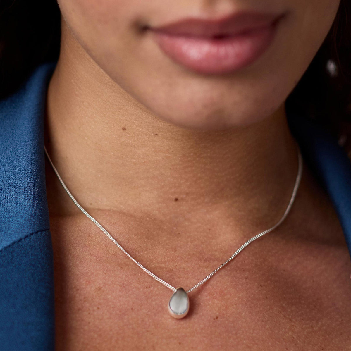 Silver adjustable necklace with a delicate wave pendant on an 16.5 to 17.5 inch chain.
