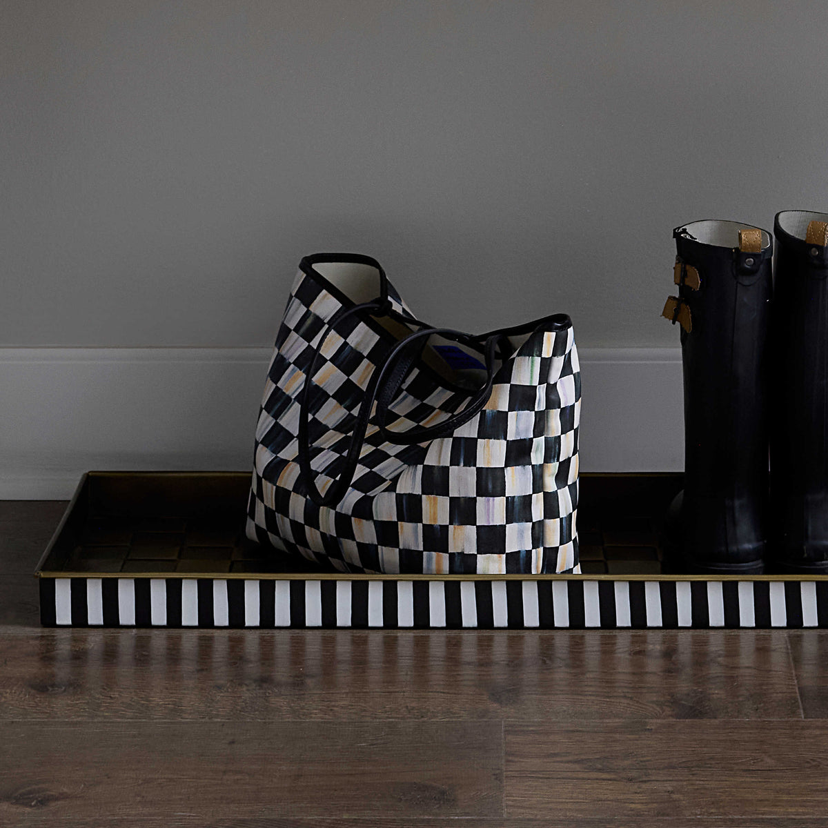 Courtly Check Marche Medium Tote with black and white checkered pattern on a striped tray.