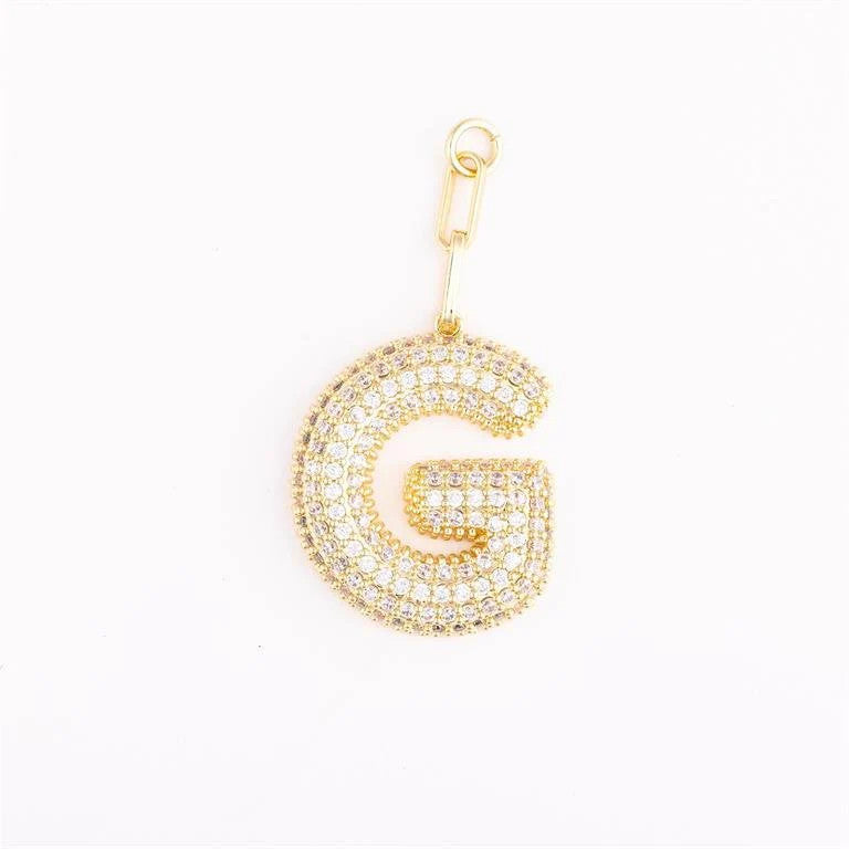 Heather-colored charm bag with gold plating, pave crystals, initial engraving option, and one-inch extender chain.