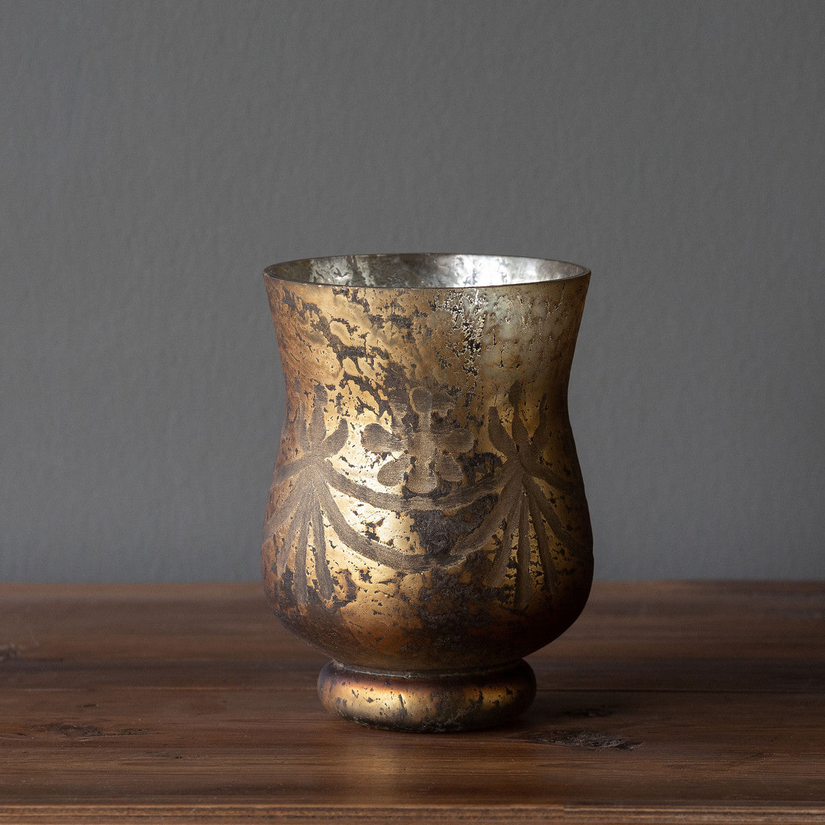 Antiqued bronze hurricane lamp with etched glass shade featuring a decorative pattern.