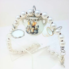 Porcelain teapot charm necklace featuring M.I. Hummel artwork on a silver chain