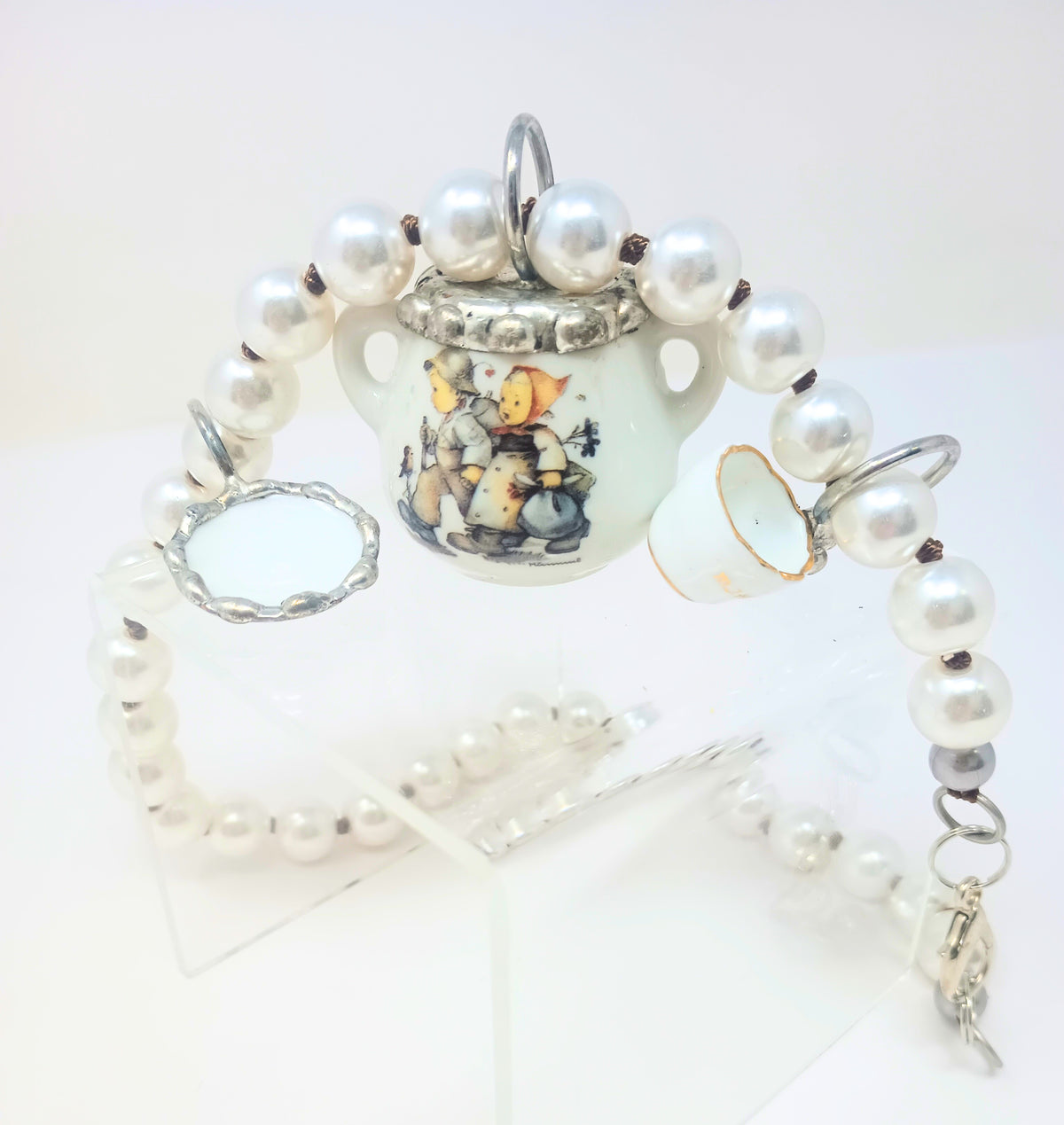 Porcelain teapot charm necklace with M.I. Hummel artwork on a silver chain