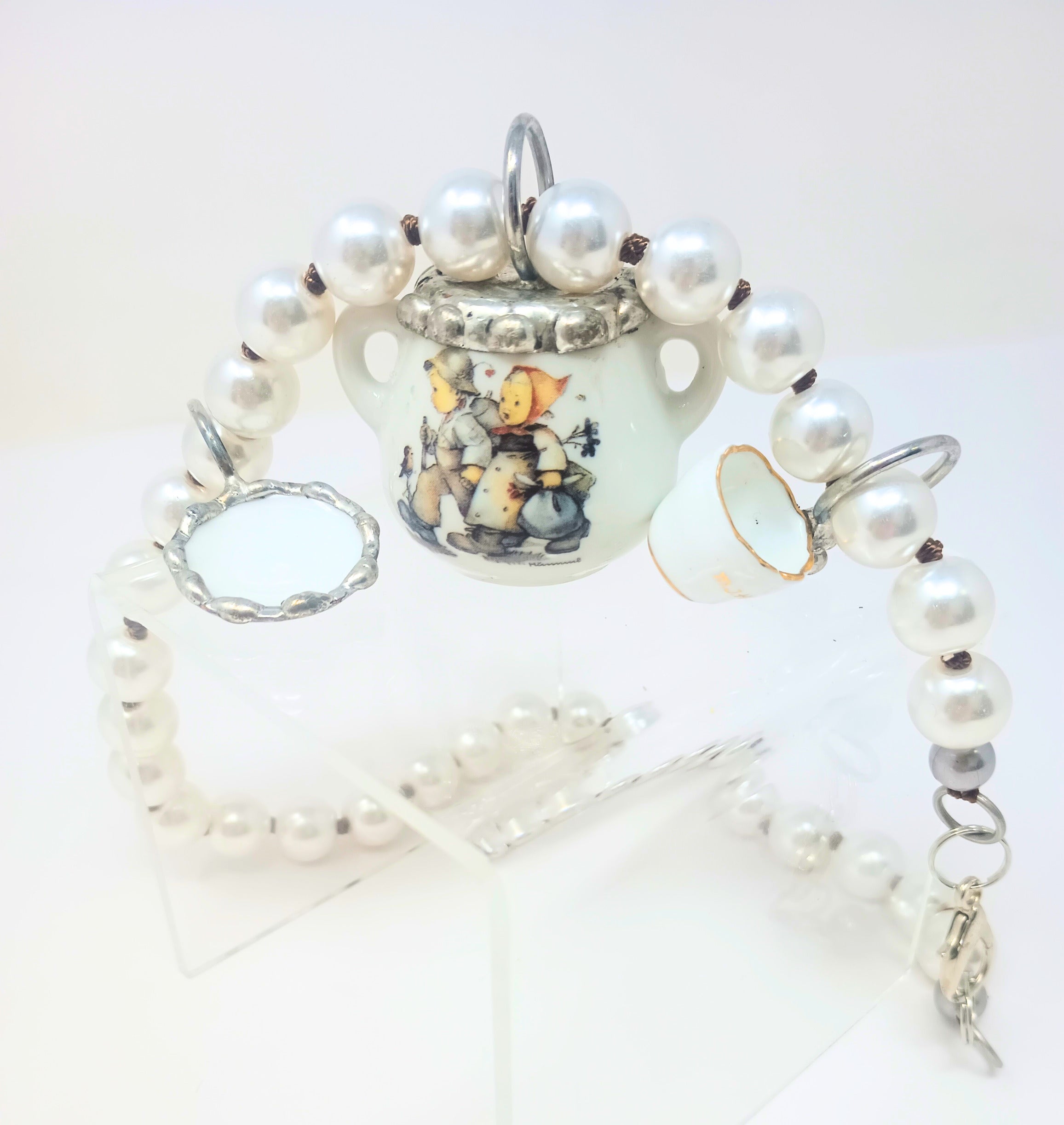 Porcelain teapot charm necklace with M.I. Hummel artwork on a silver chain