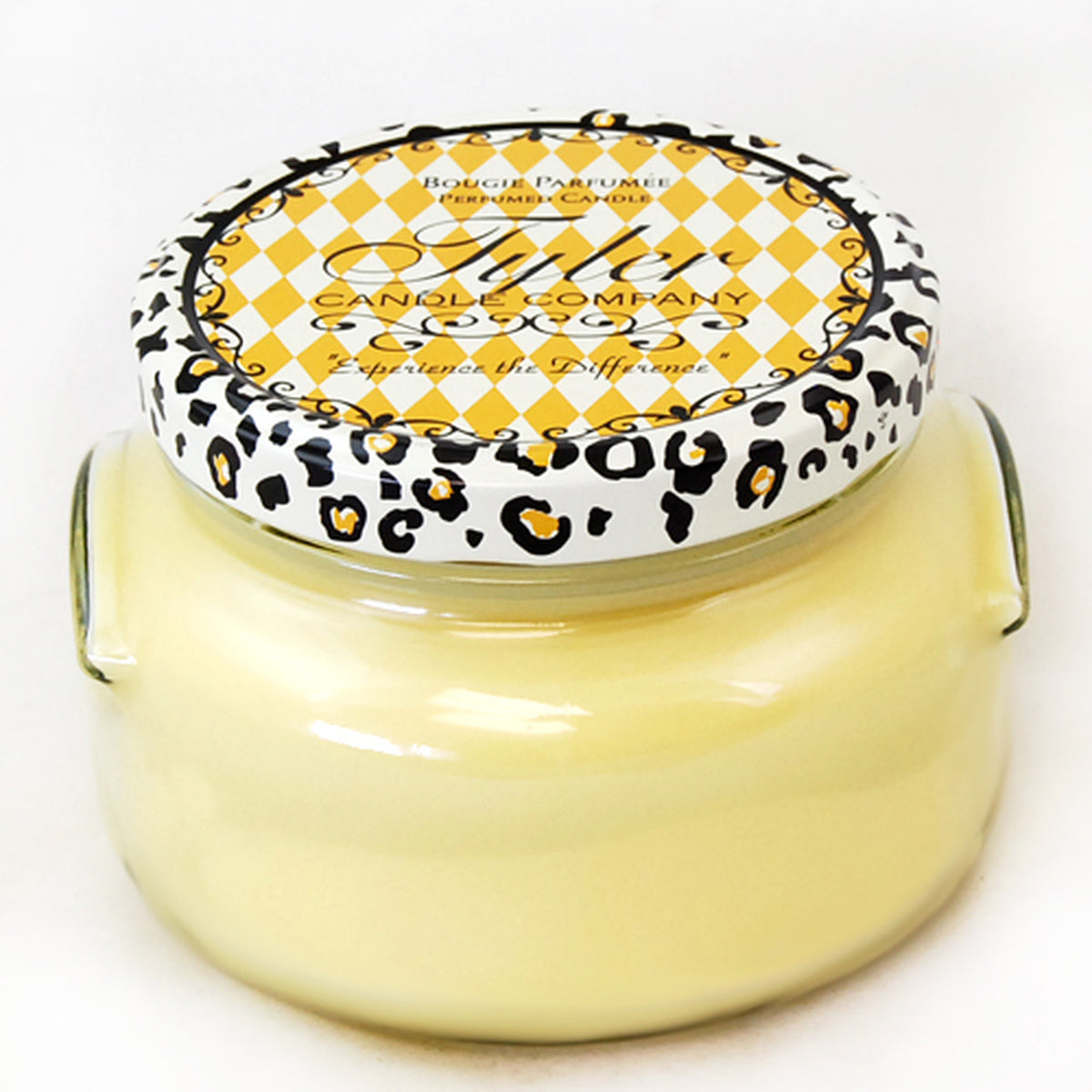 A large glass jar candle with a white wax surface inside.