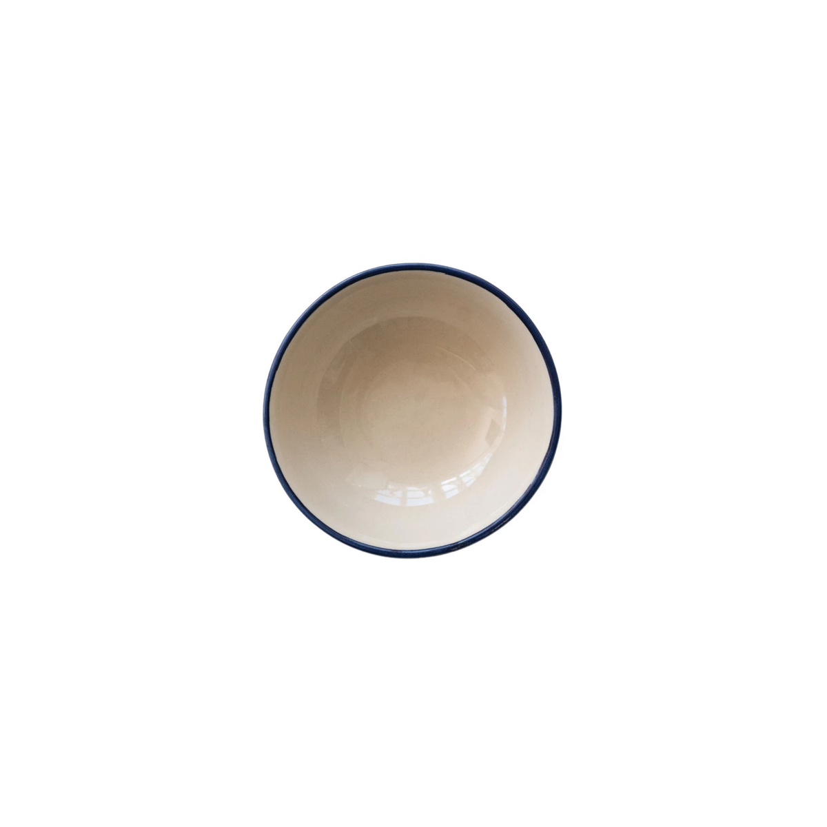 Top view of a small hand-painted stoneware bowl with a cream interior and dark blue rim.