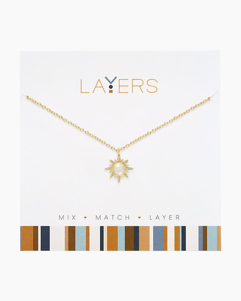 Gold Sunburst Layers Necklace featuring a sun-shaped pendant with a white stone on a gold chain.