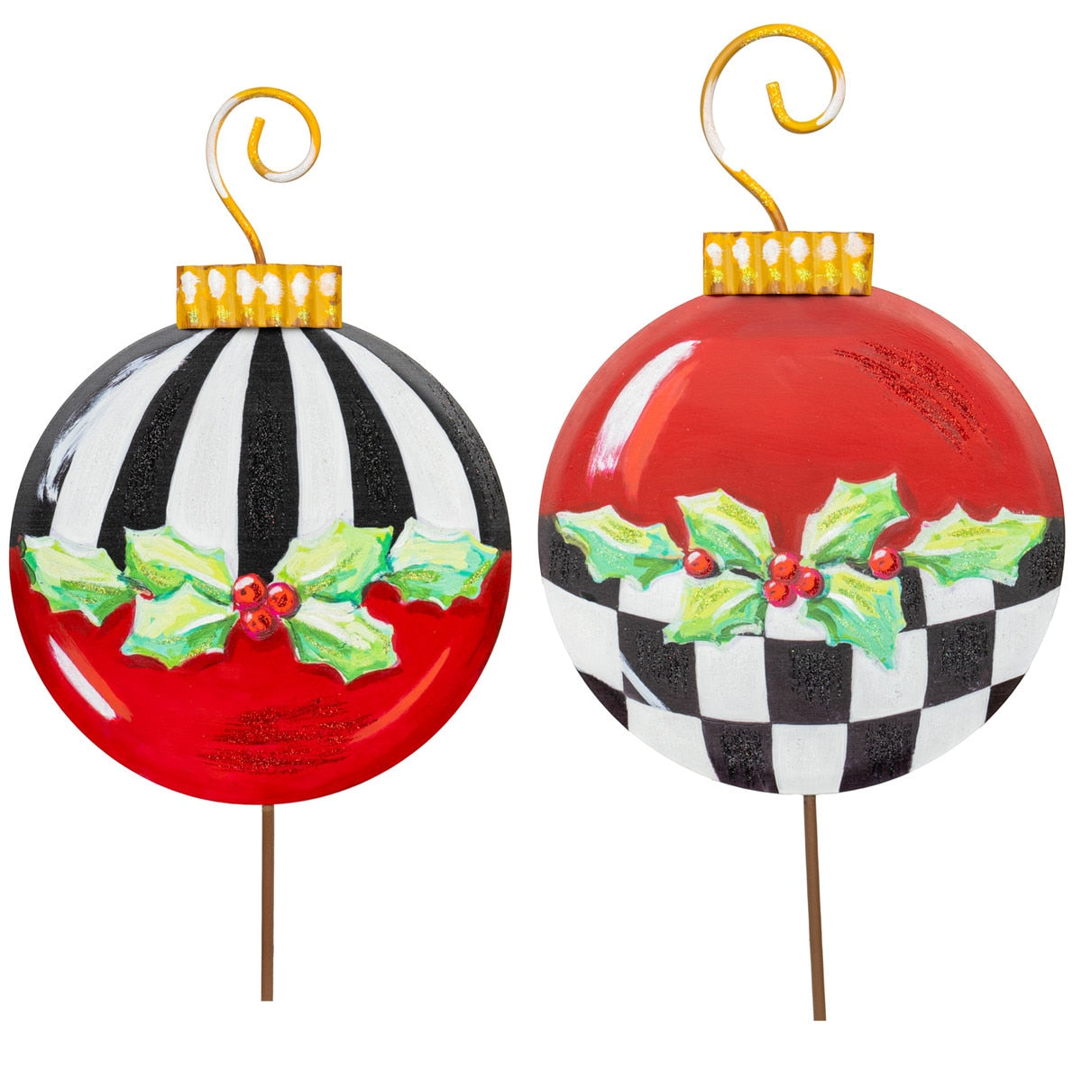 Two metal Christmas ornaments on stakes, one red with black and white stripes, the other red with a black and white checkerboard pattern, both with holly.
