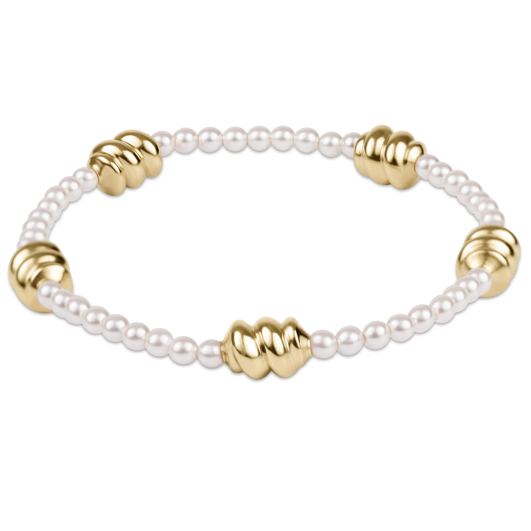 Gold-tone bracelet featuring a central 3mm pearl with delicate chain links.