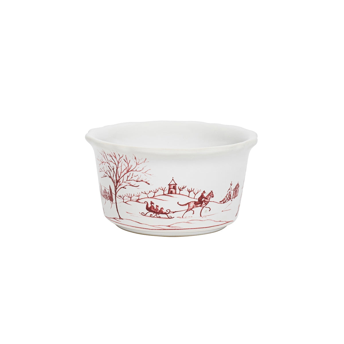 White ceramic ramekin with a fluted rim and red winter scene of a horse-drawn sleigh.