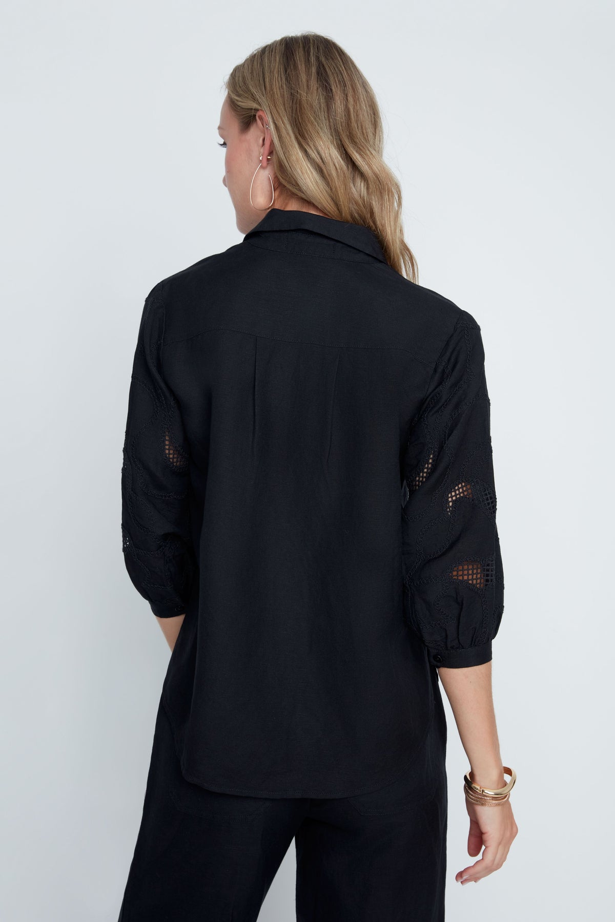 Hannah Woven Blouse in soft neutral tone with relaxed fit, button front, subtle textured sleeves, and sheer panel accents.