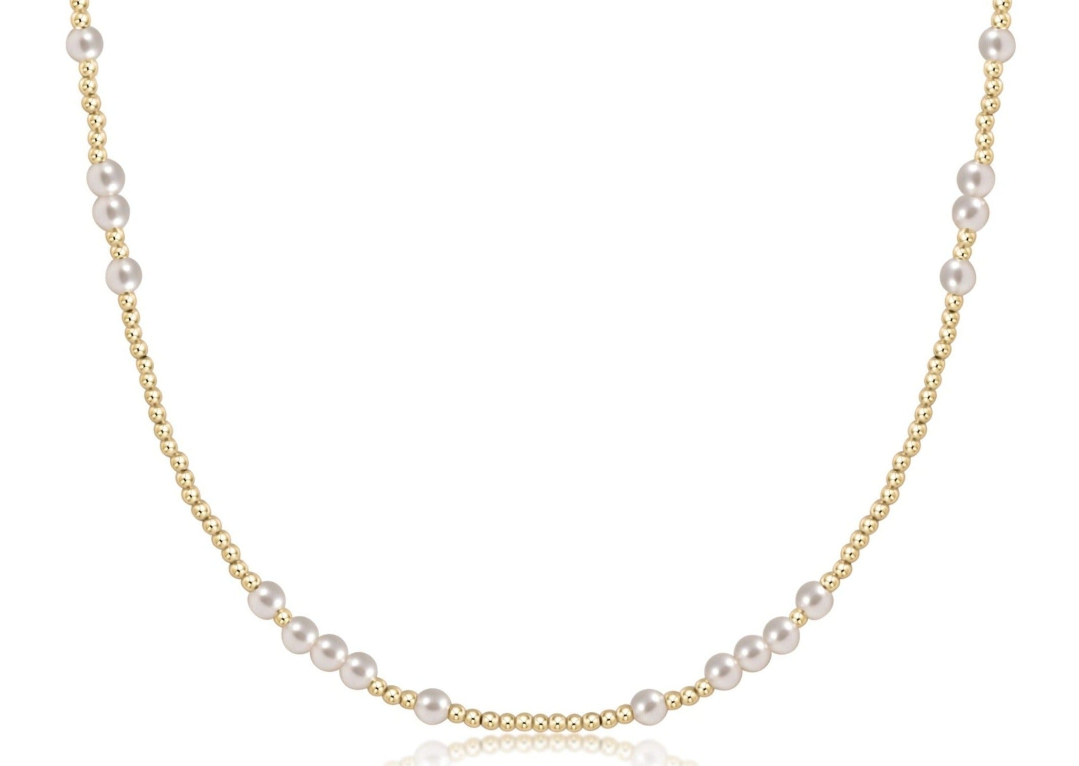A close-up view of a choker necklace featuring four-millimeter white pearls and two-millimeter gold-filled beads.