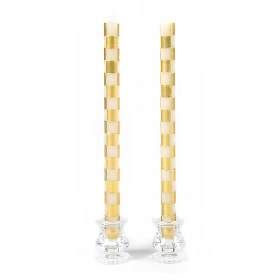 Set of two tall dinner candles with a gold and ivory checkered pattern in glass holders.