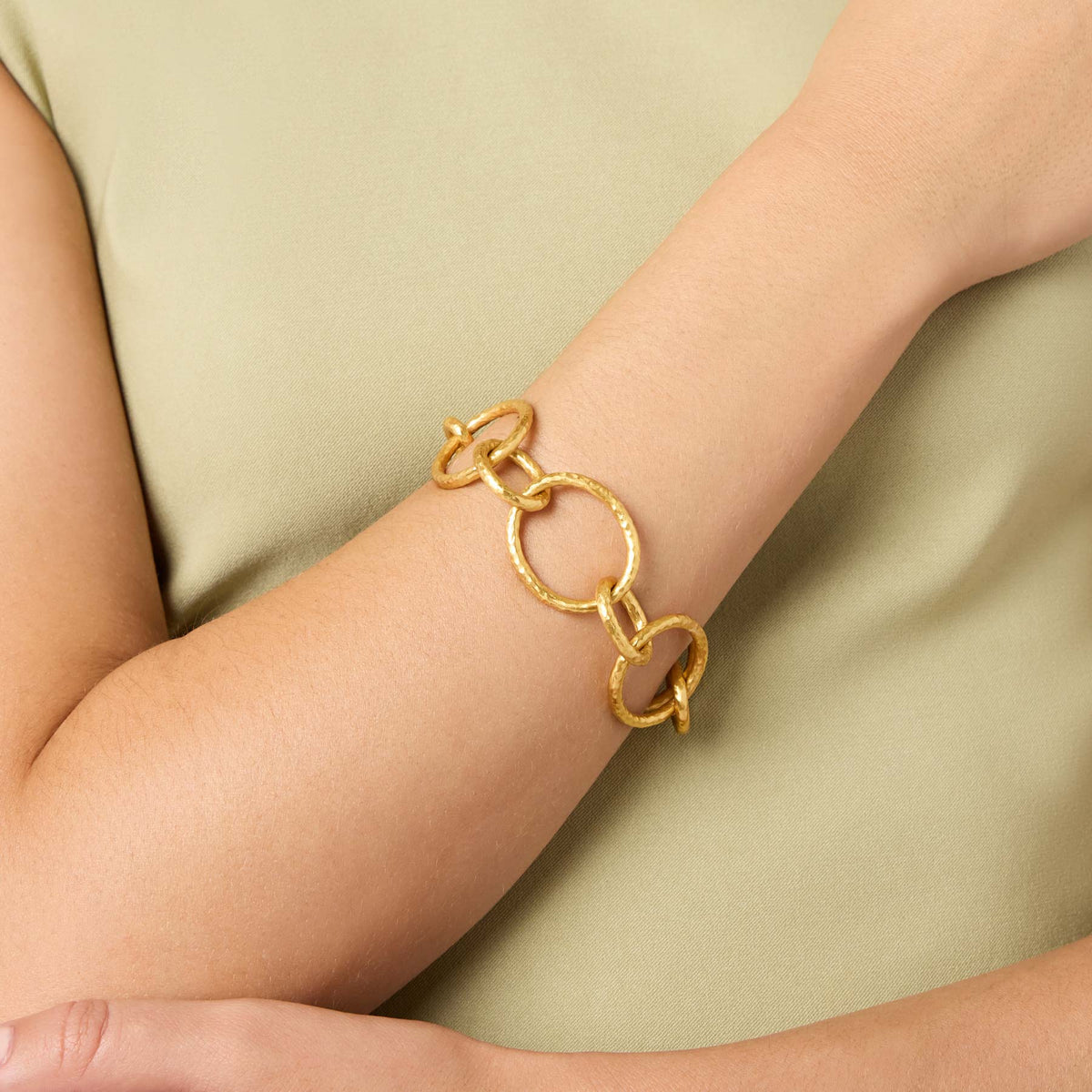 Model wearing the Catalina Light Link Bracelet, a 24K gold plated chain with hammered oval loops.