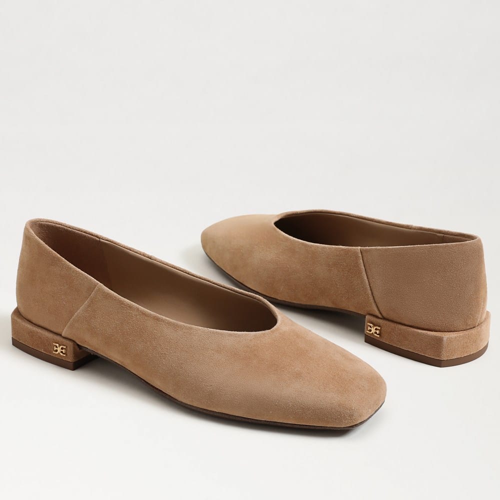 Pair of tan suede Kasey square toe ballet flats with a low block heel and gold logo detail.