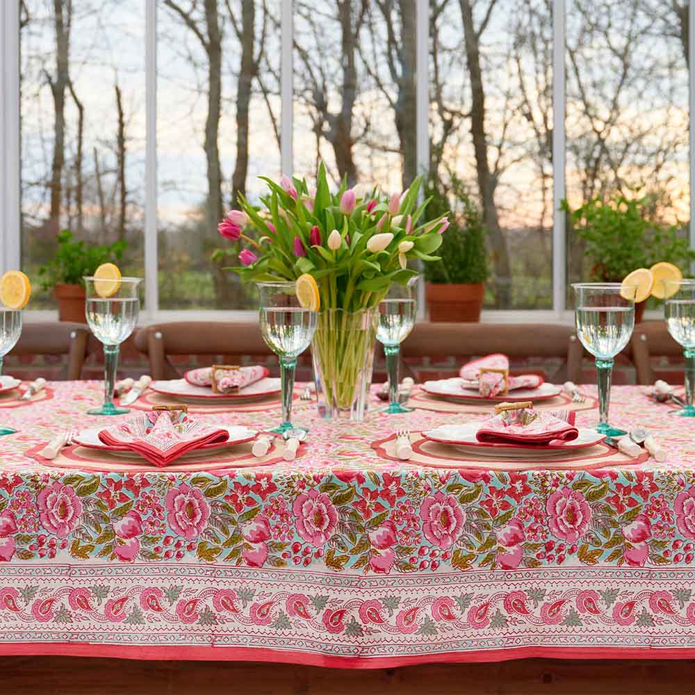 Wildflower Garden Tablecloth with pink floral patterns on a set table with tulips and glassware.