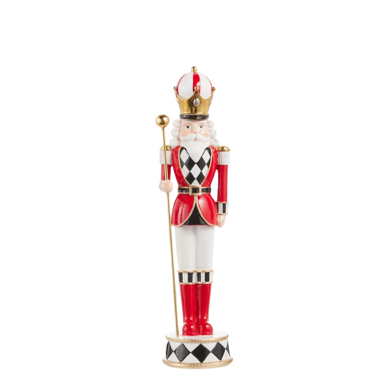 Red and white nutcracker figurine with a gold crown, holding a staff on a checkered base.
