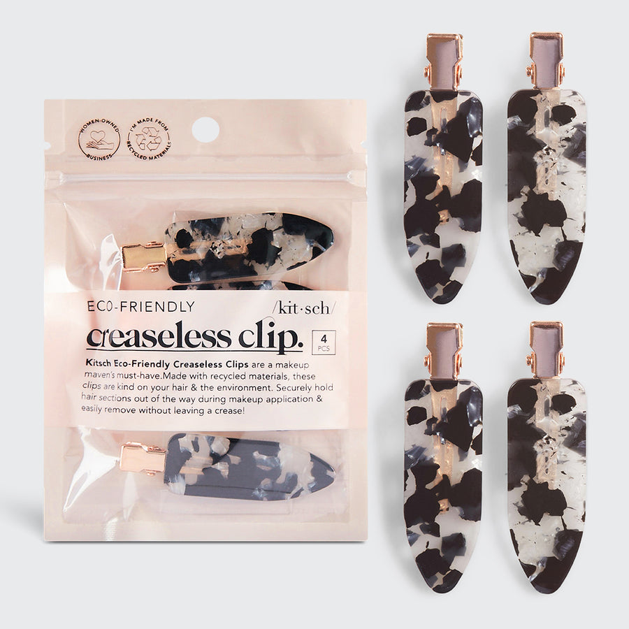 Four black and white marble patterned creaseless hair clips with rose gold hardware and packaging.