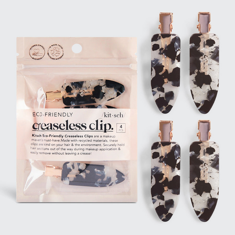 Four black and white marble patterned creaseless hair clips with rose gold hardware and packaging.