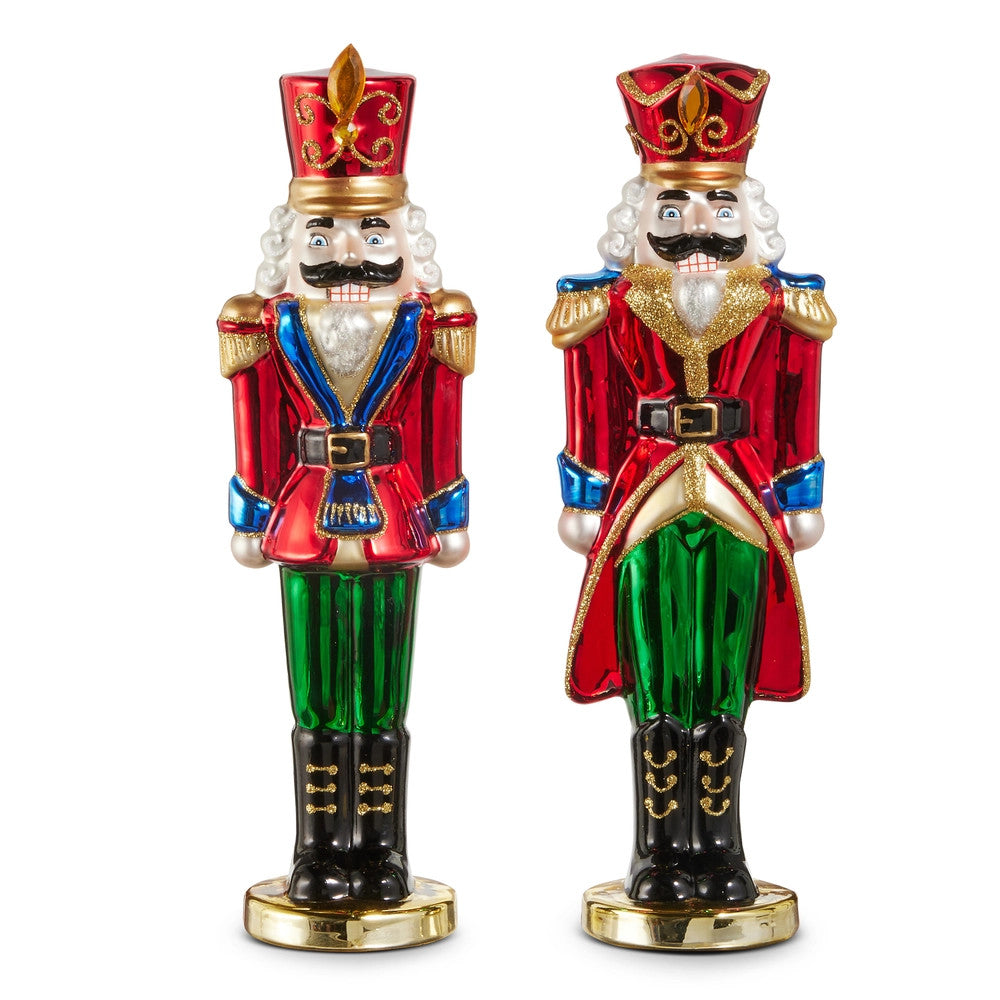 Two 11-inch glass nutcracker soldier figurines in red, green, and gold festive attire.