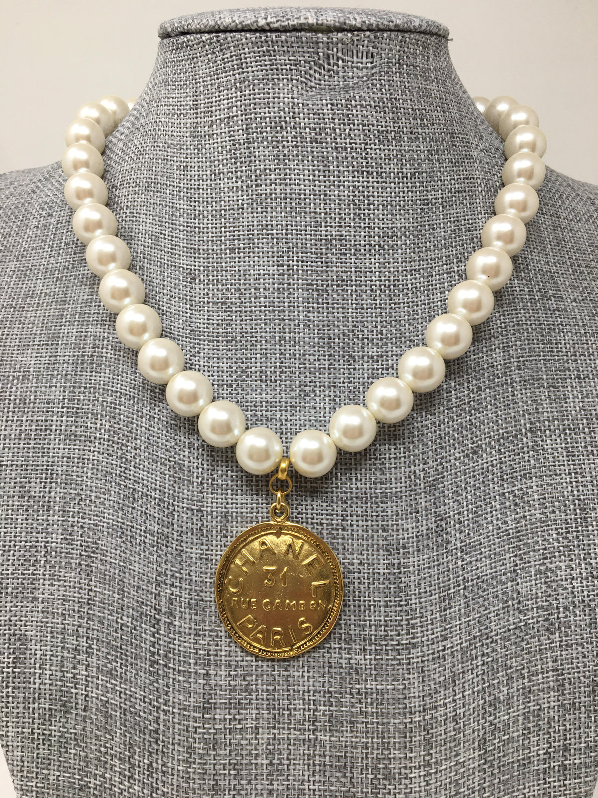 Pearl necklace with an 8 3/4-inch length featuring a Chanel-style coin pendant.