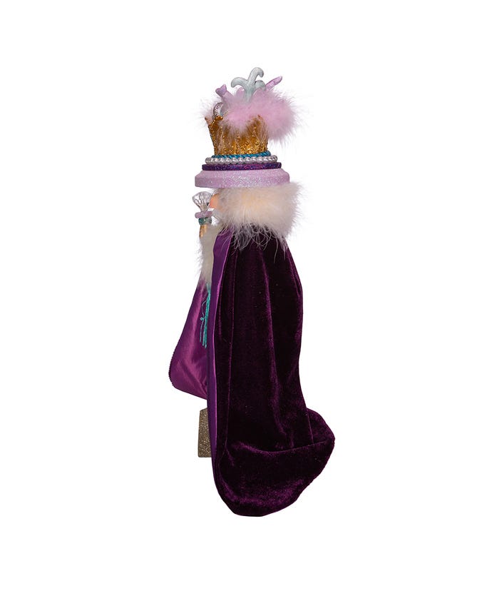 Side view of an 18-inch Hollywood Two Turtle Doves Nutcracker wearing a long purple velvet cape.