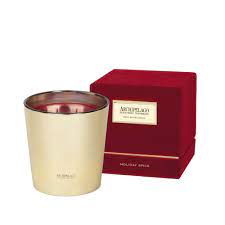 Holiday Spice three-wick candle in a clear glass jar with an off-white wax and black wicks.