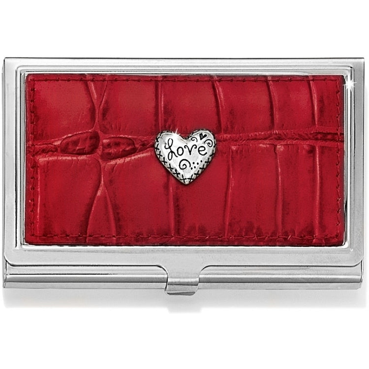 Red Italian leather card case with sculpted heart accent and clasp closure.
