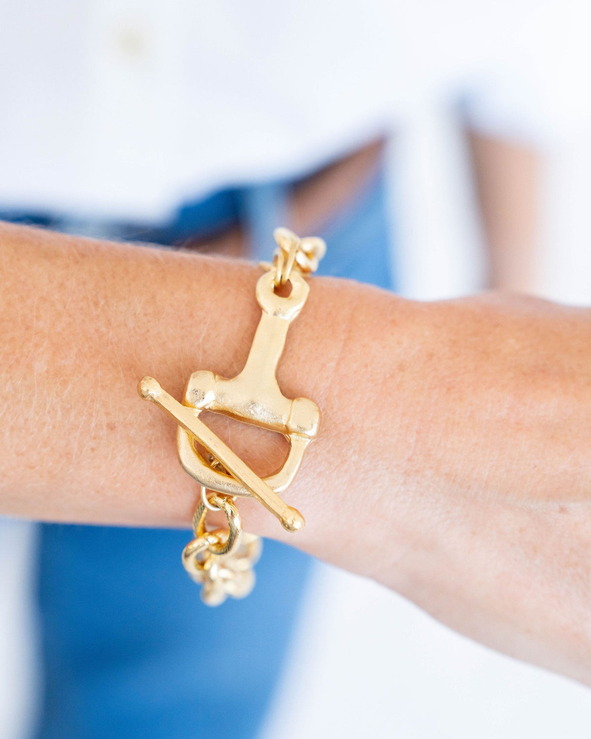 Gold toggle bracelet with a hammered finish and a bar closure.