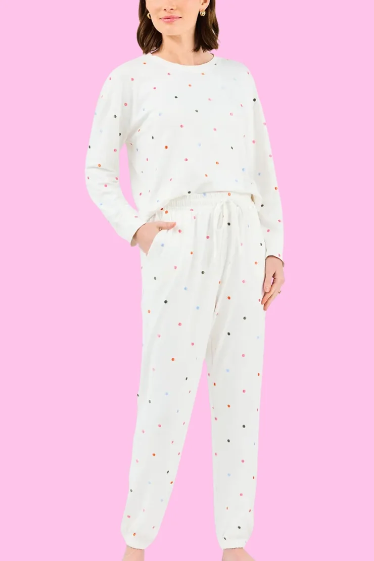 Woman wearing a white Sophie Jogger Set with a colorful confetti dot print and elastic waist.