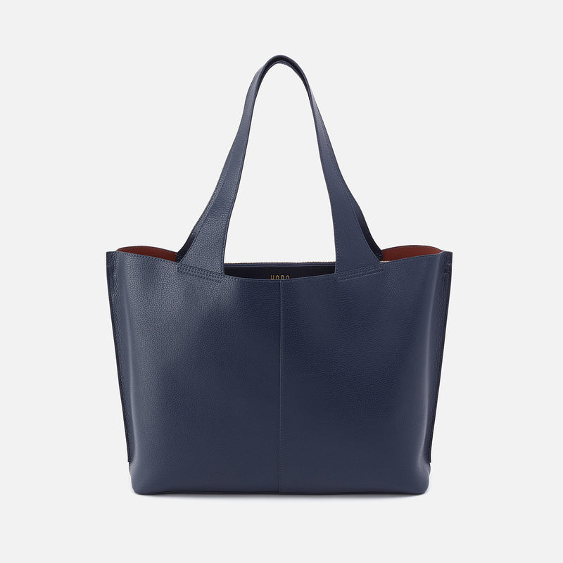 Vida Large Tote in solid leather with brushed antique brass hardware, coconut shell interior lining, and luggage trolley sleeve.
