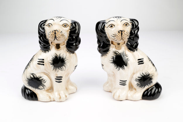 Set of two Staffordshire terrier figurines in black glazed ceramic with white accents.
