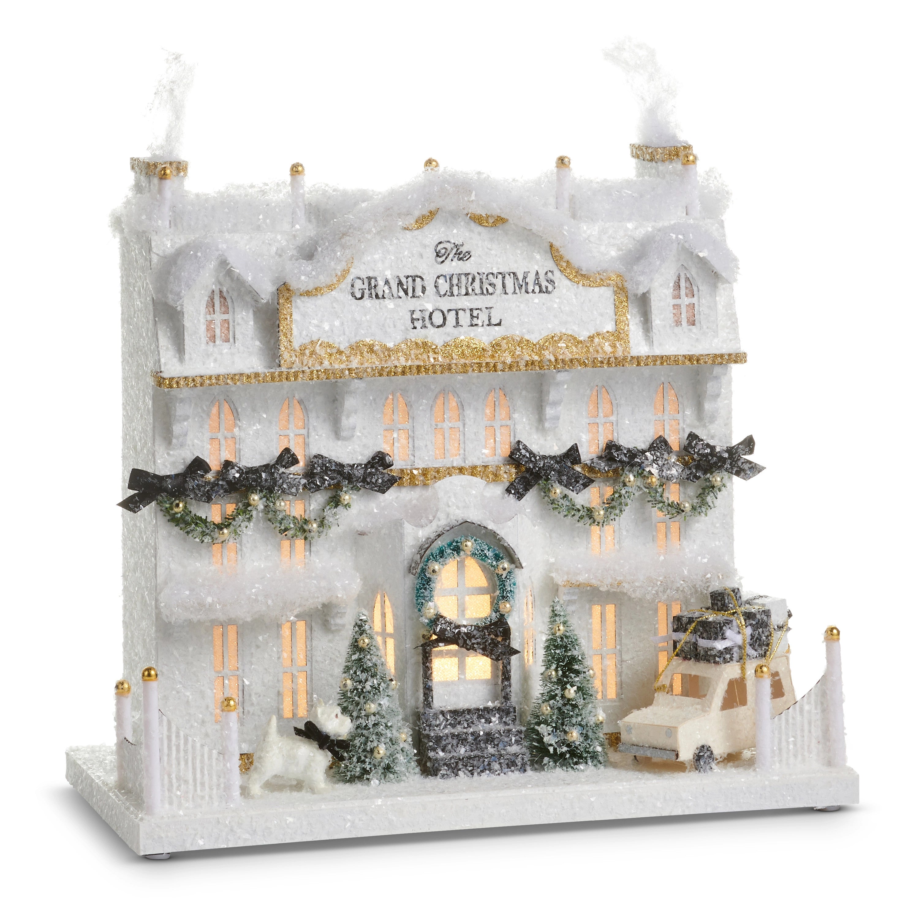 14.5 inch lighted paper Grand Christmas Hotel with snow, trees, a dog, and a car with gifts.